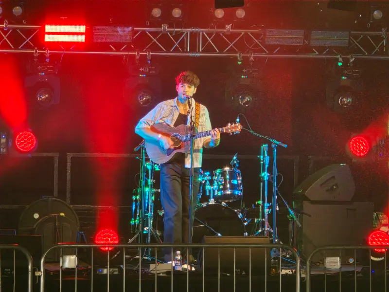 Acoustic guitarist performing under Audioserv stage lighting at Wetherby Beer Festival